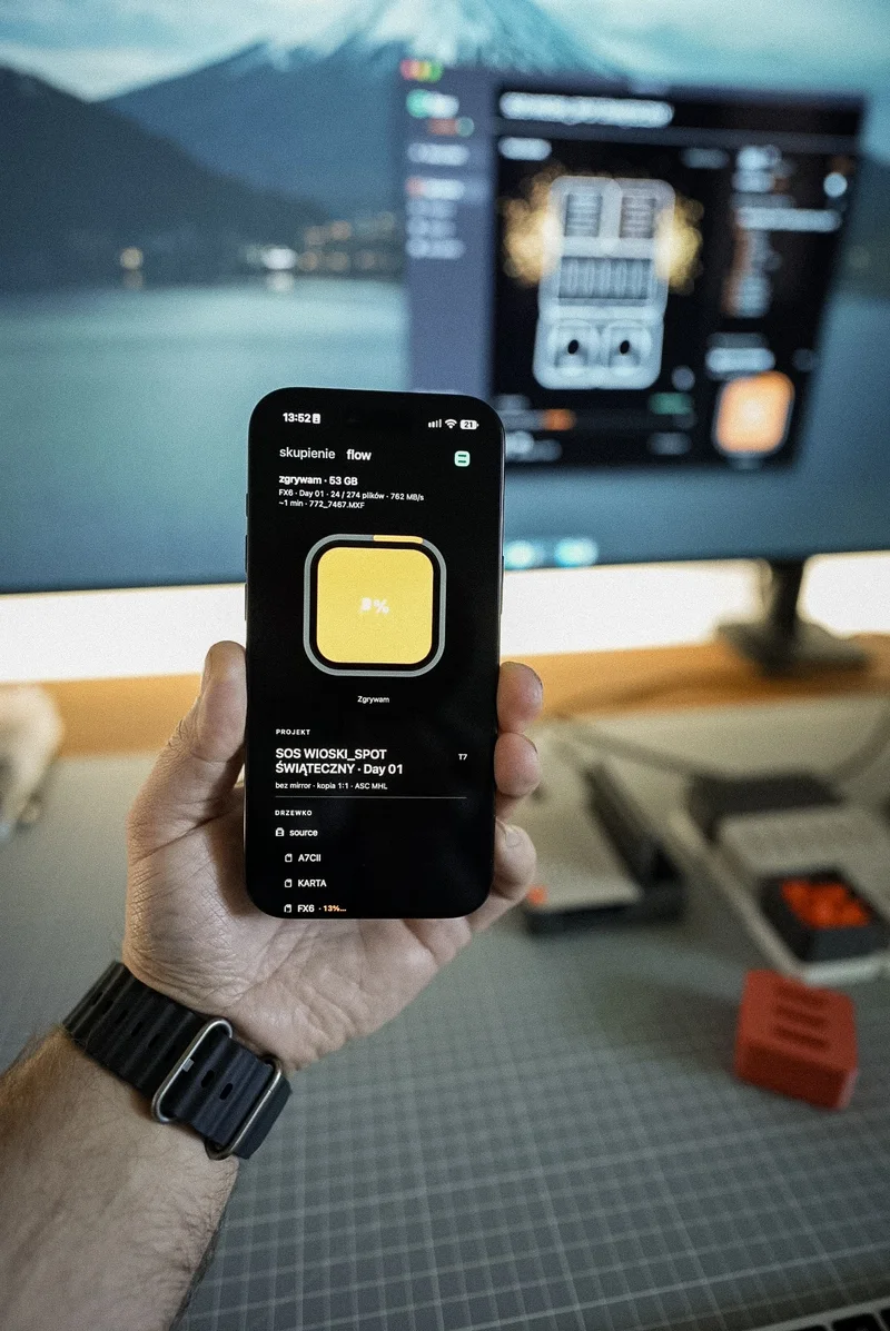 iPhone in hand showing an ingest in Habitat Flow, Mac behind