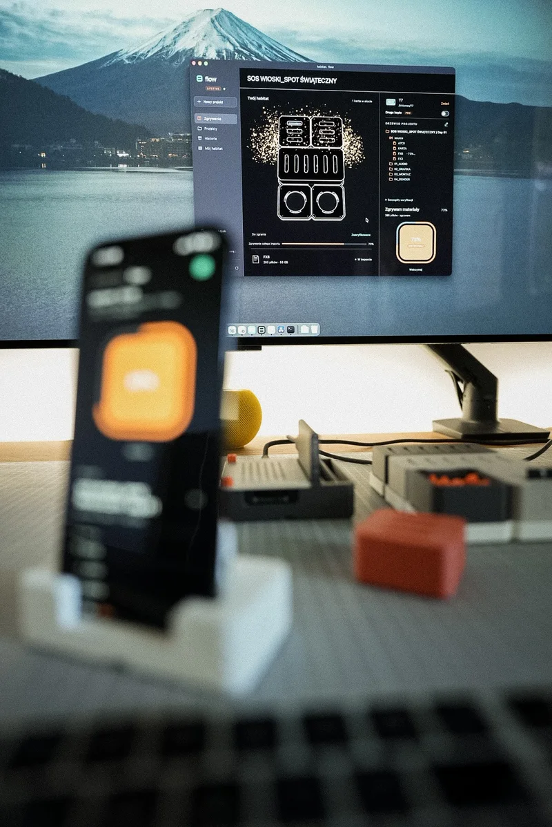 The Mac ingests a card, the iPhone stands in front of the monitor